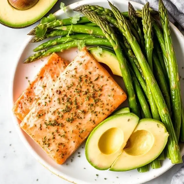 A keto-friendly meal with salmon, avocado, and asparagus.